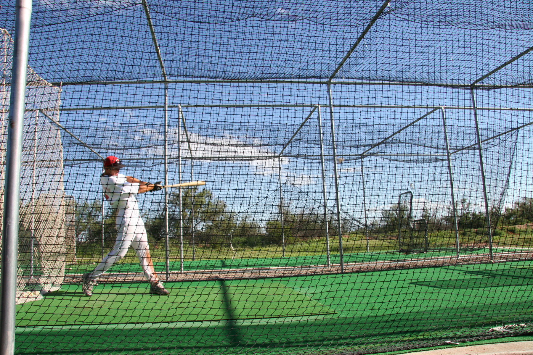 Person playing inside batting cage