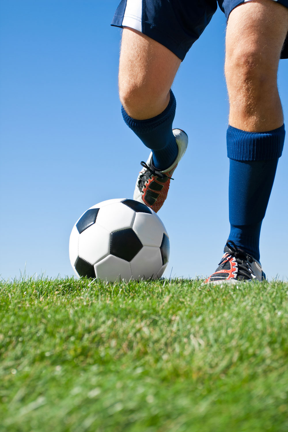 man playing soccer on backyard turf