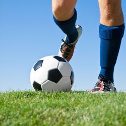 man playing soccer on backyard turf